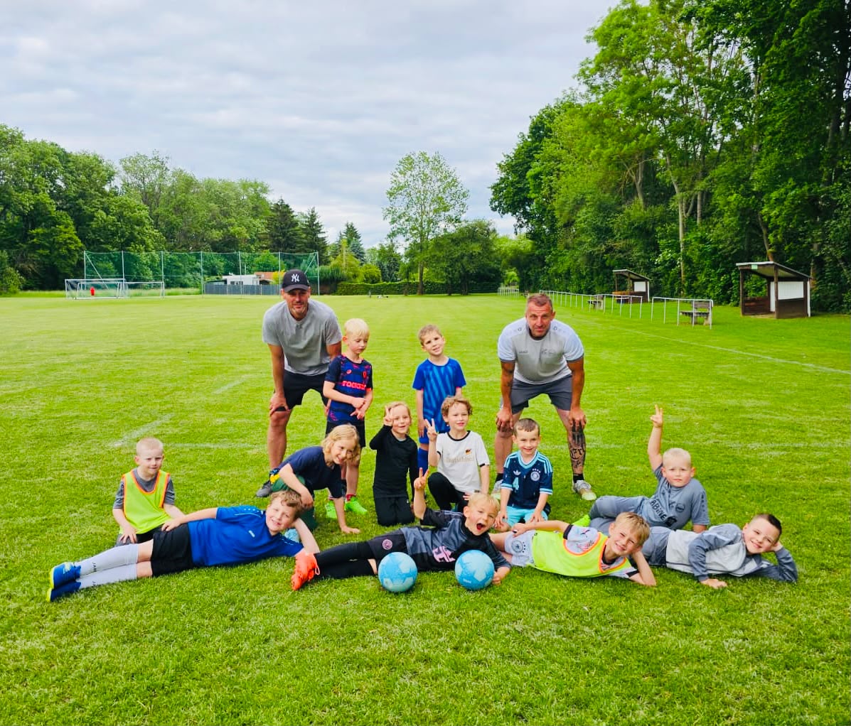 Mannschaftsfoto der G-Jugend mit Trainern auf dem Sportplatz